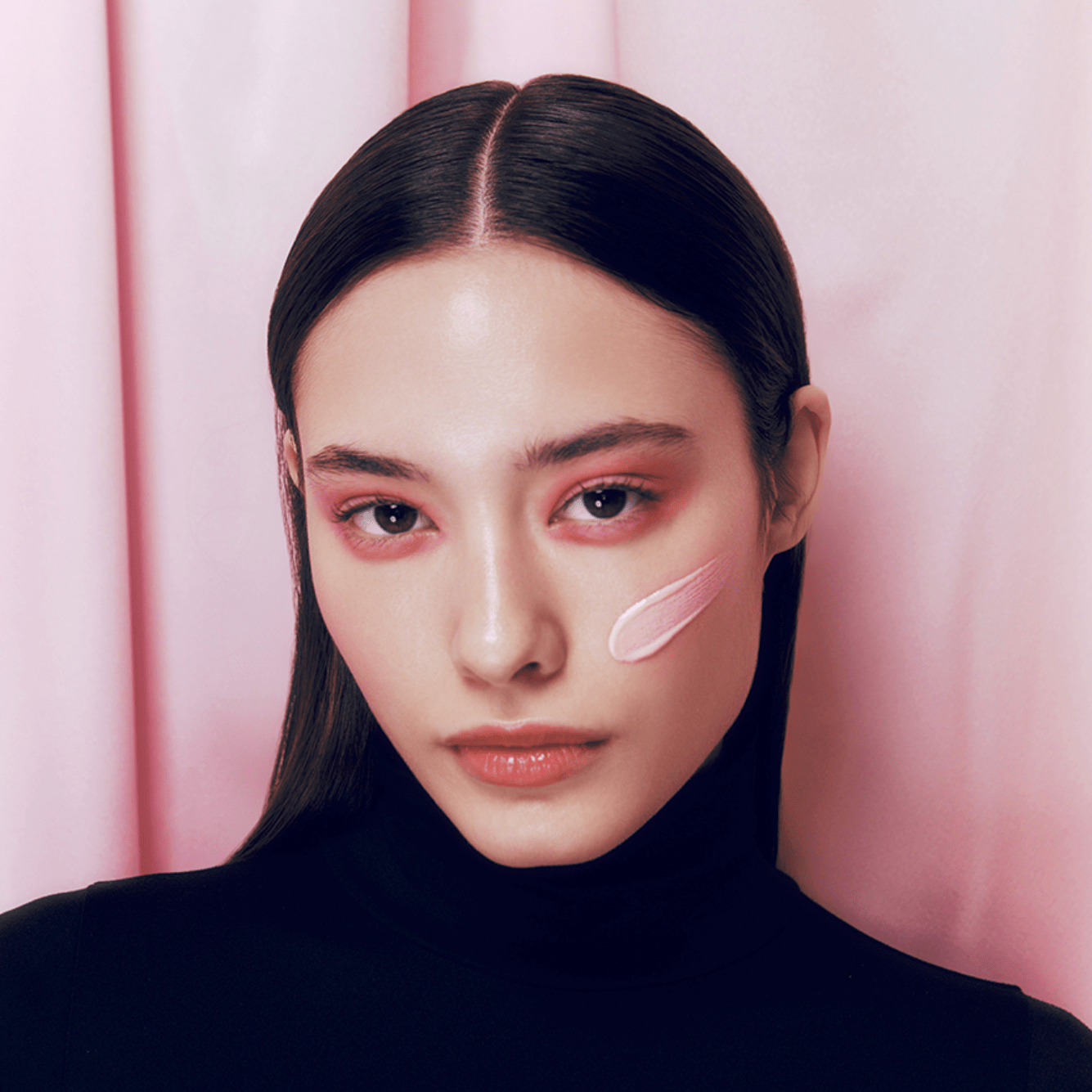 d'Alba Waterfull Tone-Up Sun Cream (Pink) Person wearing a black turtleneck with a pink background
