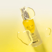 d'Alba White Truffle First Spray Serum  with droplet effect on a yellow gradient background