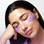 Woman wearing numbuzin purple eye masks on a plain background